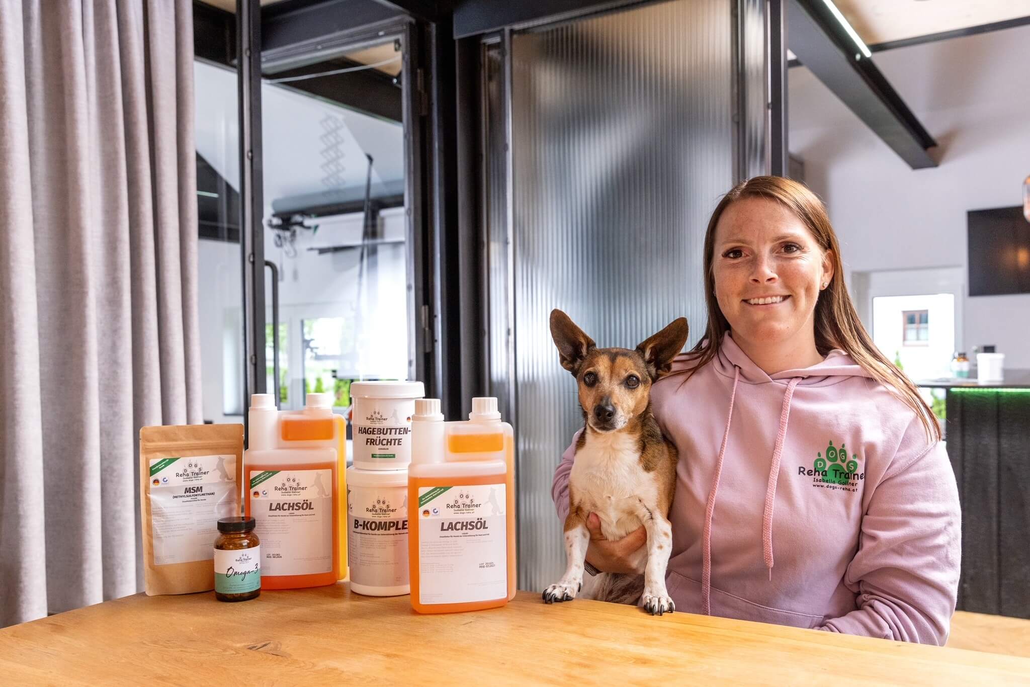 Expertin für Nahrungsergänzungsmittel für Hunde mit Produkten auf dem Tisch mit Hund